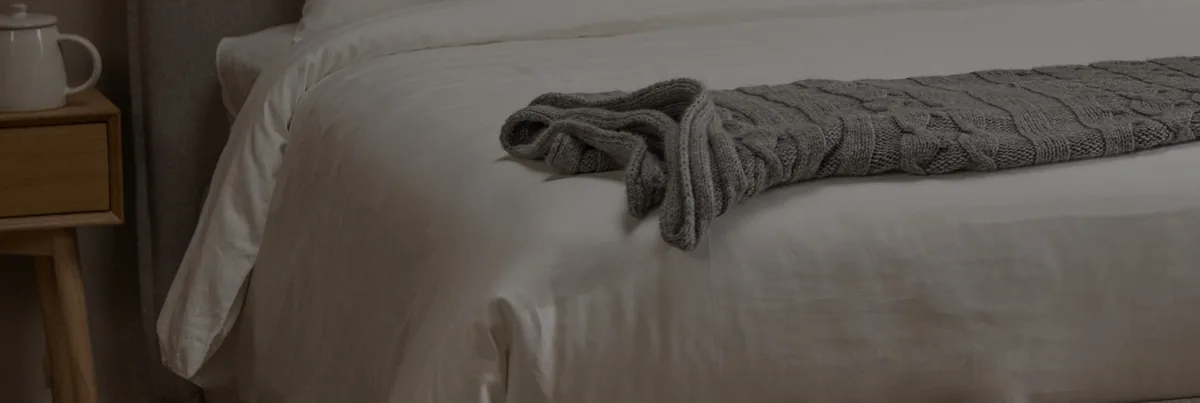 Dettaglio di letto con plaid in maglia (foto Dorelan)